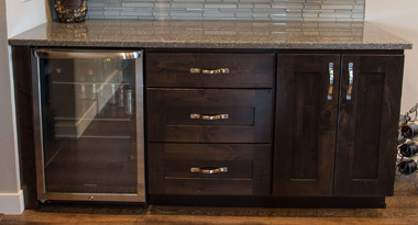 Home mini-bar station with dark cabinets, a wine cooler, stone countertops and glass tile backsplash